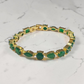 krivoya Ankita tennis bracelet featuring oval and emerald-cut green stones set in a gold-tone metal band