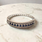 Silver bracelet with blue stones on a marble surface