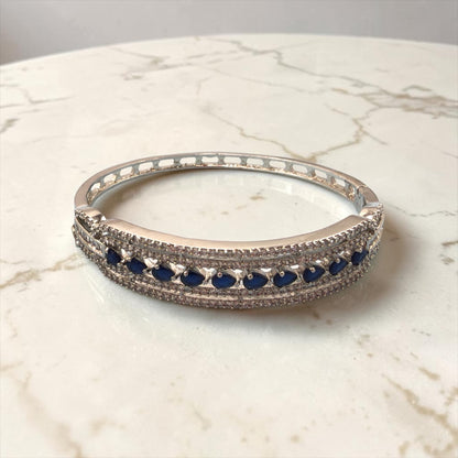 Silver bracelet with blue stones on a marble surface