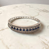 Silver bracelet with blue stones on a marble surface